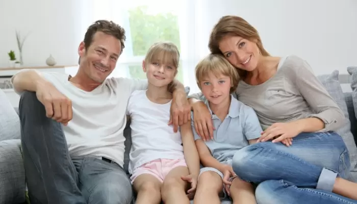 family smiling sitton on couch